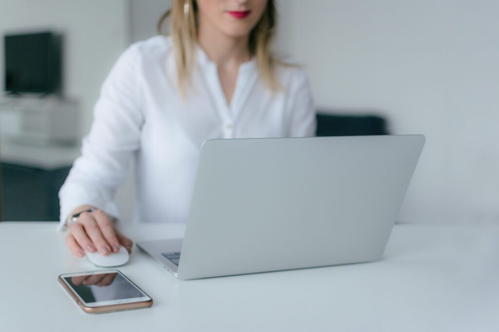 pexels photo 2265488 2265488 A woman working at a desk using a laptop and smartphone, exemplifying remote work.
