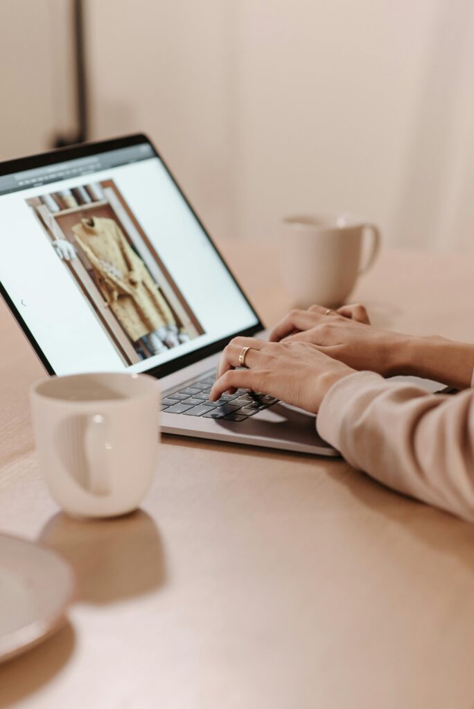 pexels photo 6443059 6443059 Close-up of hands typing on a laptop in a cozy café setting.